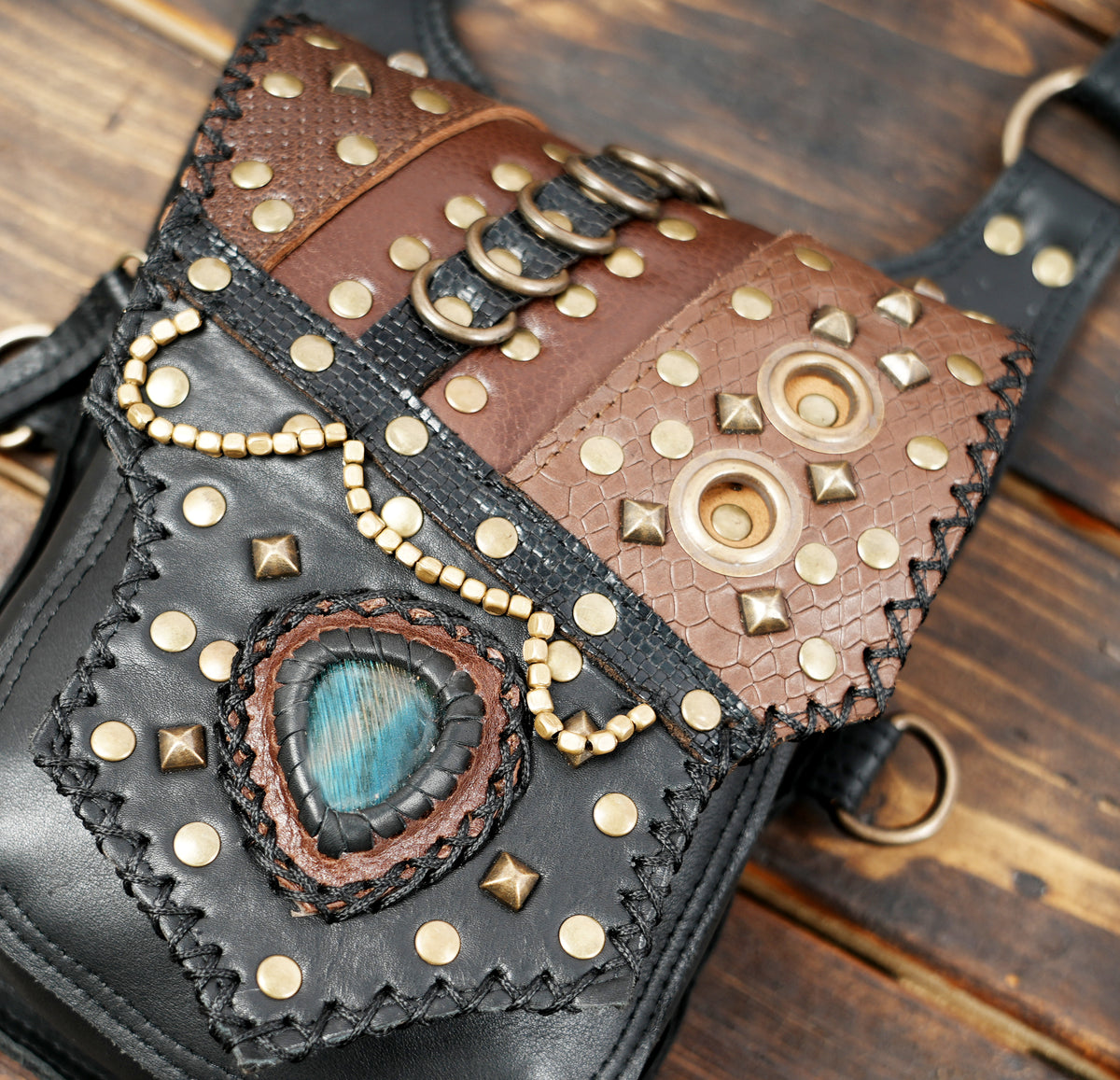 Leather rave festival bag with turquoise stone centerpiece antique brass clips and metal studs
 