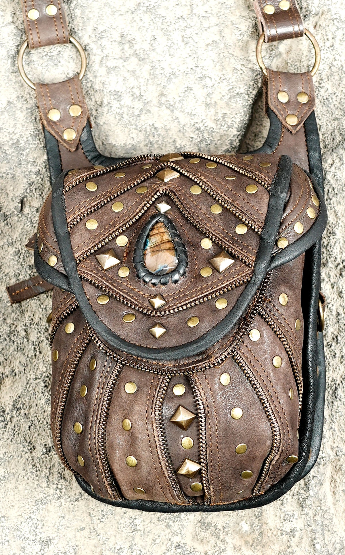 Leather shoulder harness with studded detailing and blue-green gemstone embellishments