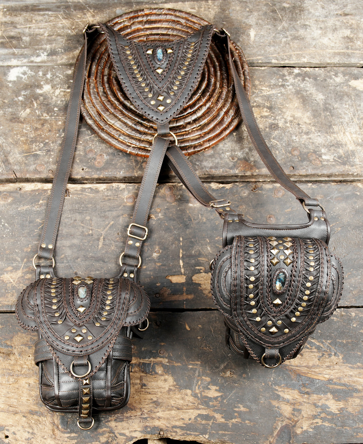 Dark brown leather hip bags with studded covers and adjustable harness belts