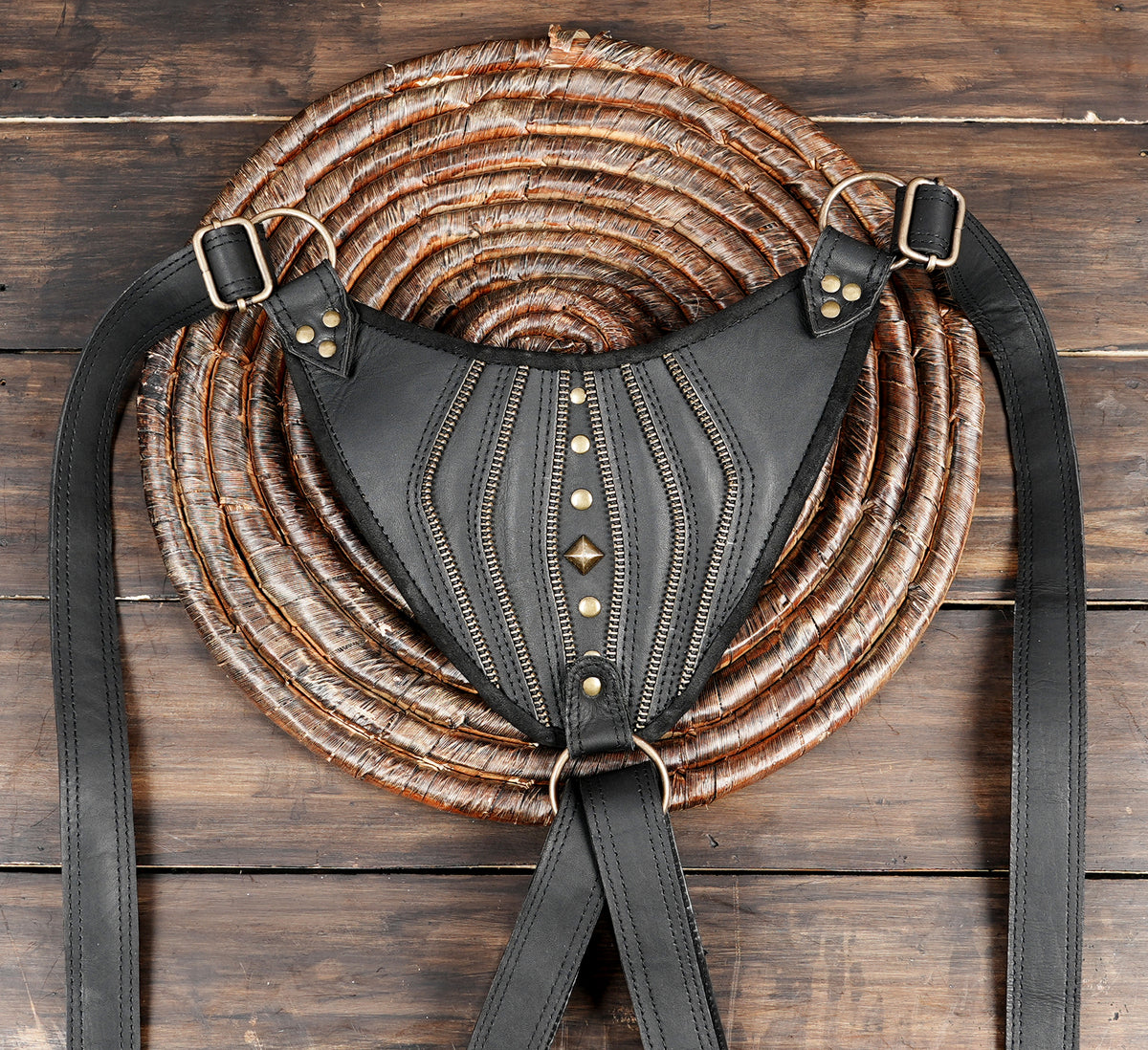 Black double pouch leather harness with decorative stitching and multiple zipper details
