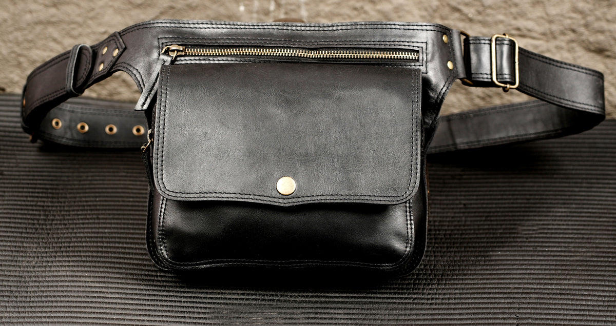 Front view of black leather belt bag with flap closure and snap button