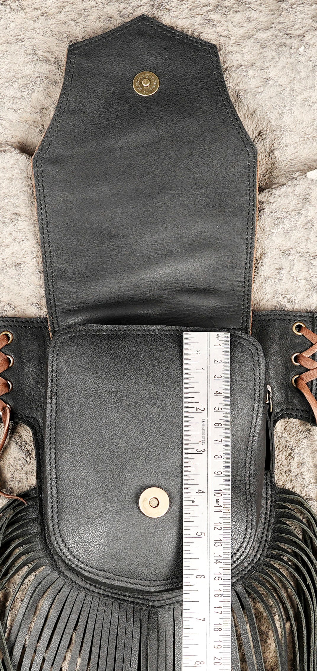 Genuine leather fringe belt styled on fur background