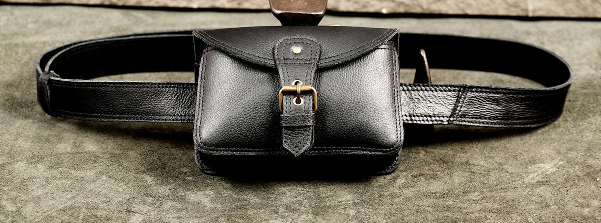 Small black leather belt bag with front buckle strap and snap flap