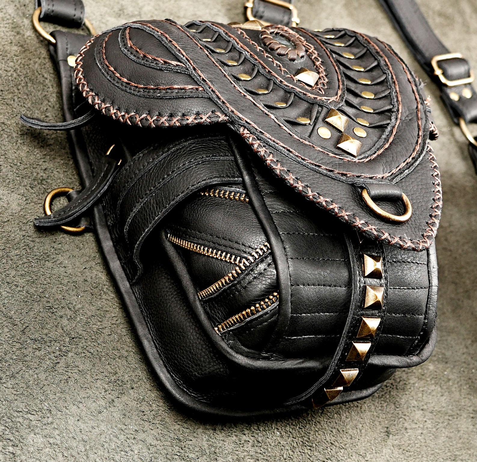 Gothic black leather shoulder rig with detailed stitching and brass studs