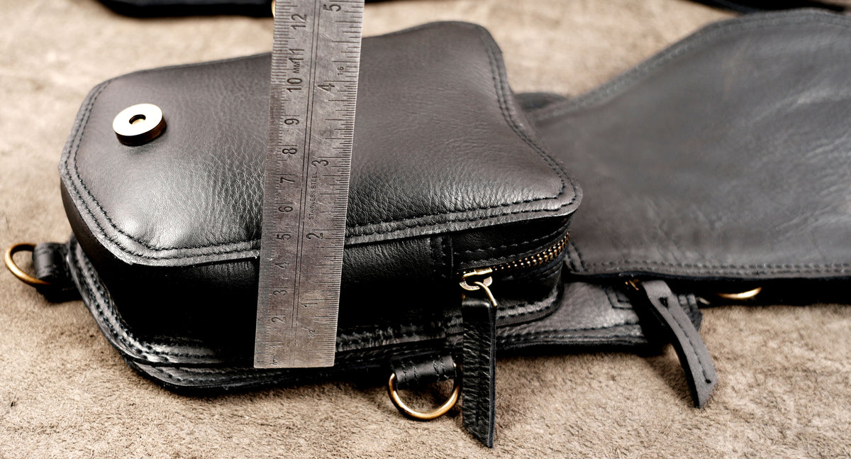 Western-inspired black leather fringe shoulder holster with double zip pockets and braided stone borders.