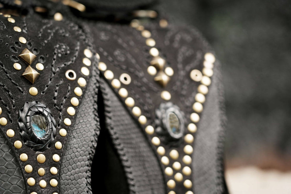 Black leather holster set with studded pockets and fringe for Burning Man festival wear.