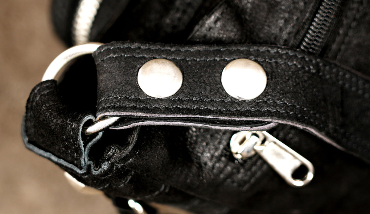 Handcrafted leather shoulder bag styled on suede background