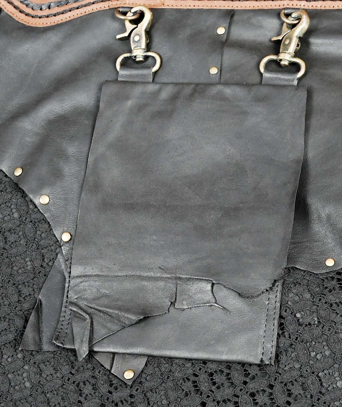 Handcrafted leather skirt with black lace overlay, close up