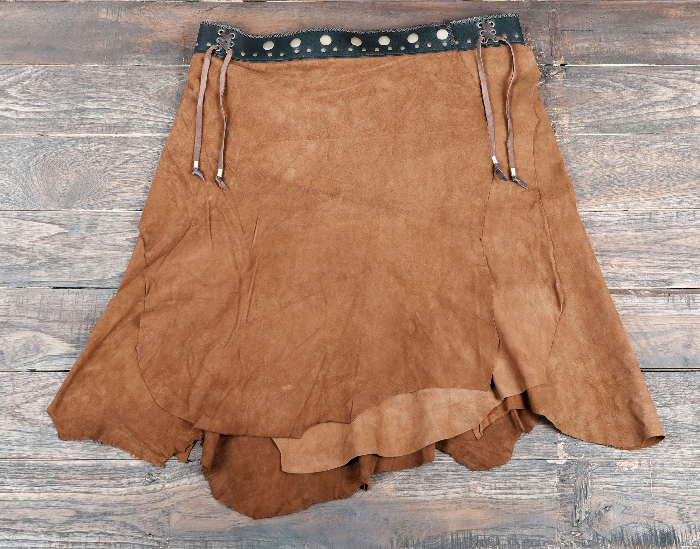 Handcrafted suede skirt styled on rustic wood background