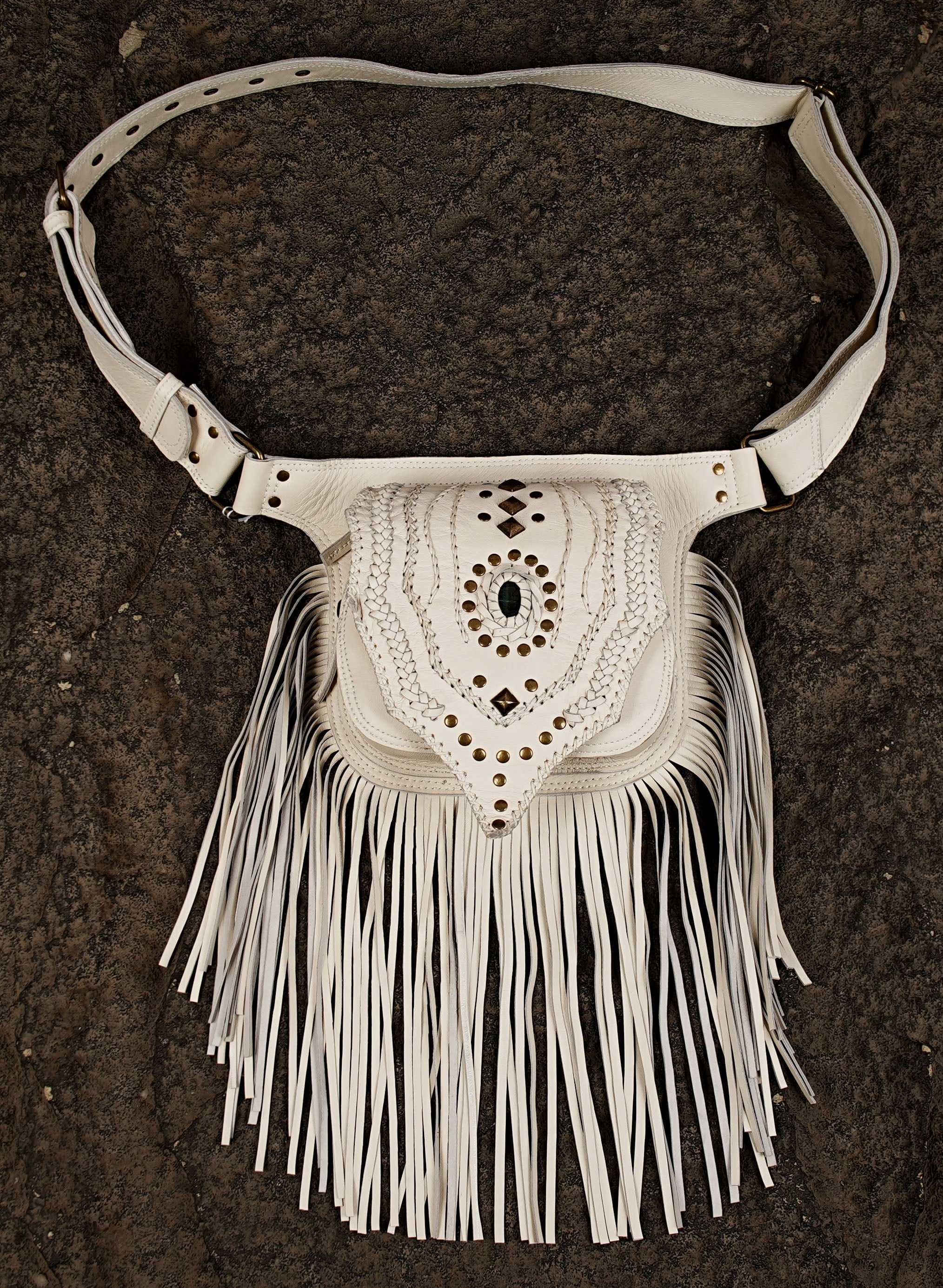 Handmade leather fringe pouch displayed on a dark background