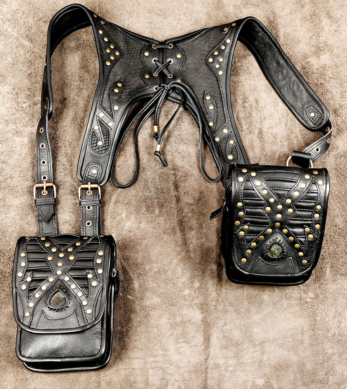 Black leather utility chest bag with brass eyelets and buckle closures
 