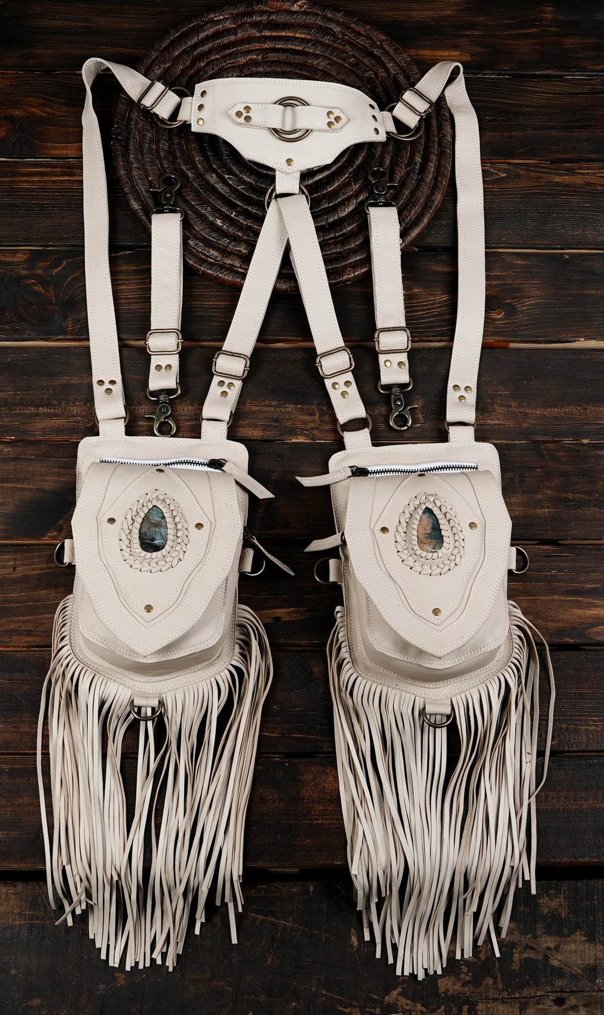 White leather body harness bag with double fringe pockets and metal hardware   