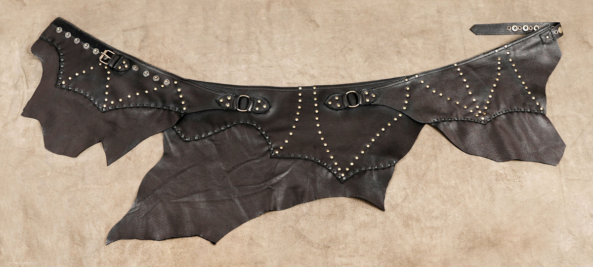 Artisan leather skirt with layered panels and geometric metal stud patterns