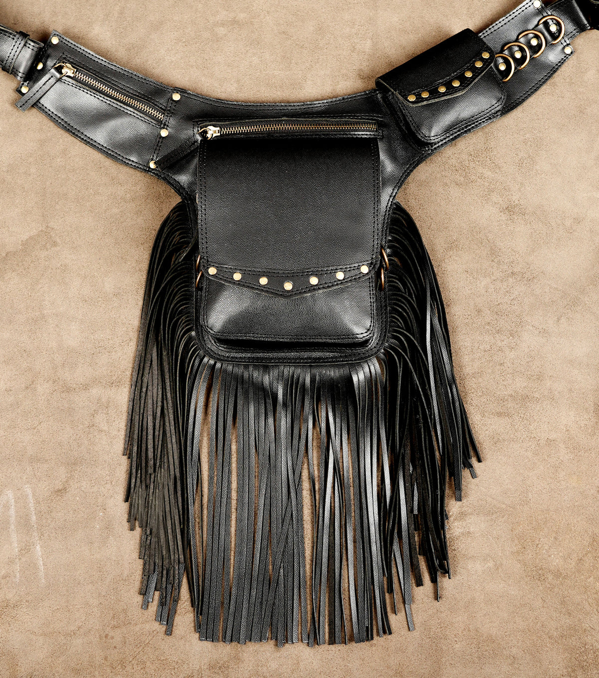 Leather hip bag with tassels and brass rings