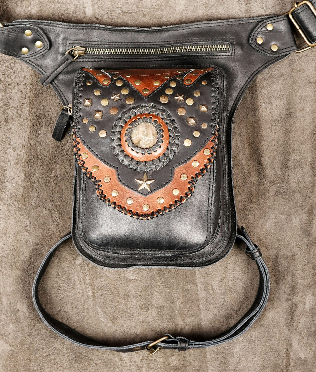 Leather holster bag with tan stone centerpiece, flat lay view