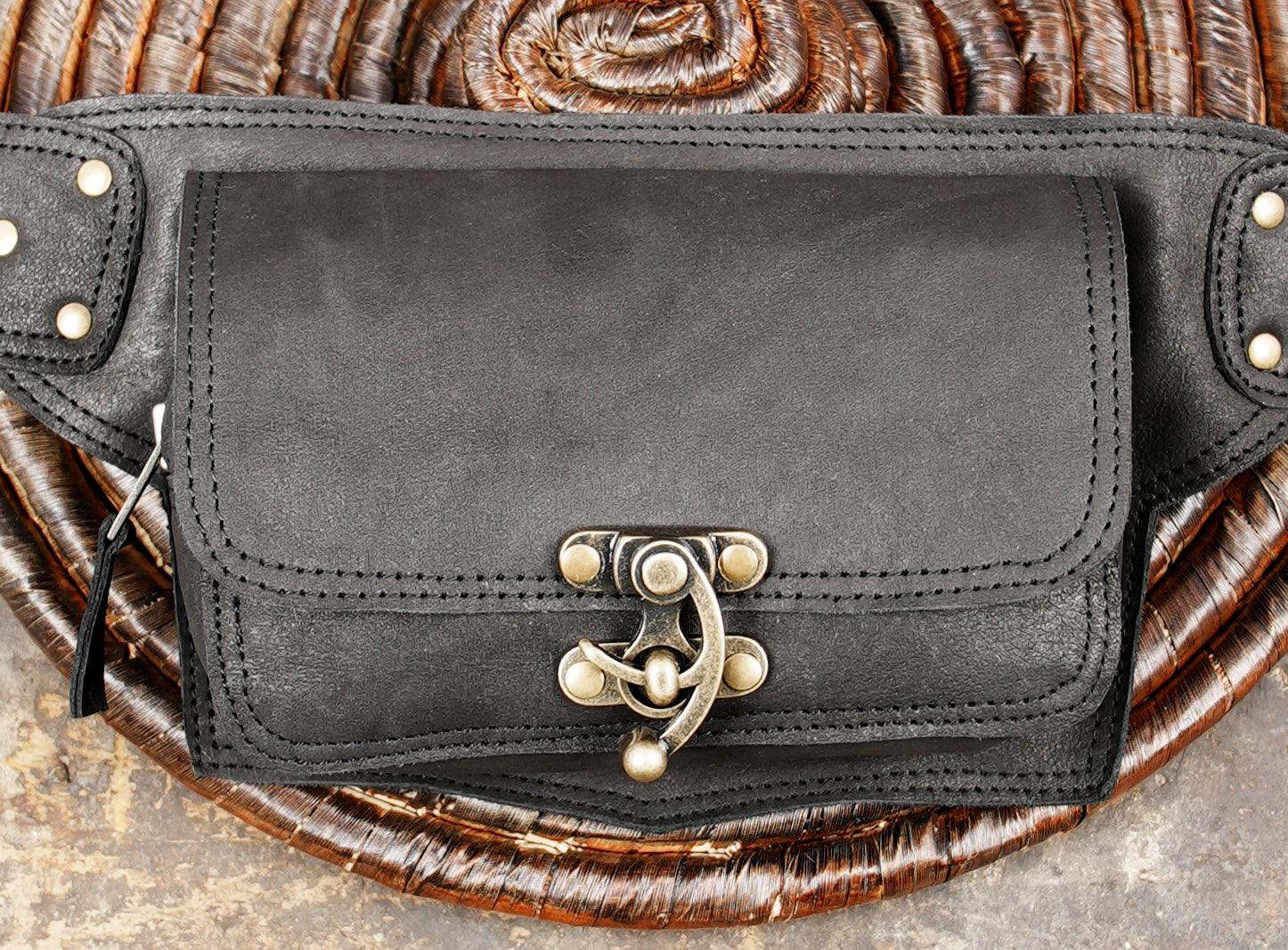 Leather pocket belt with twist lock clasps, flat lay on wood