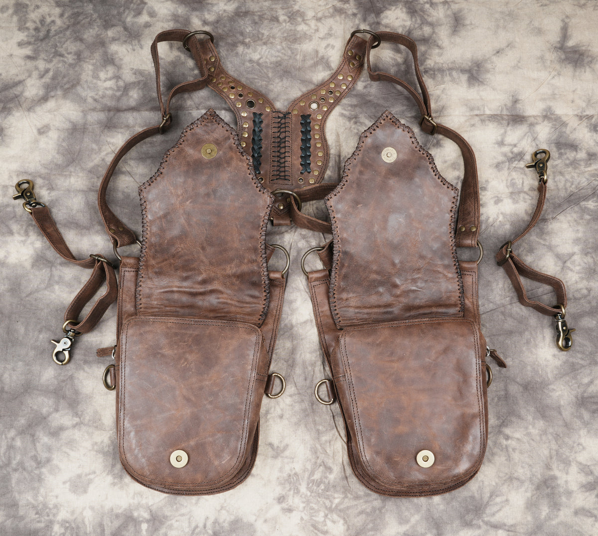 Unisex leather harness accessory with studded pockets and adjustable shoulder straps