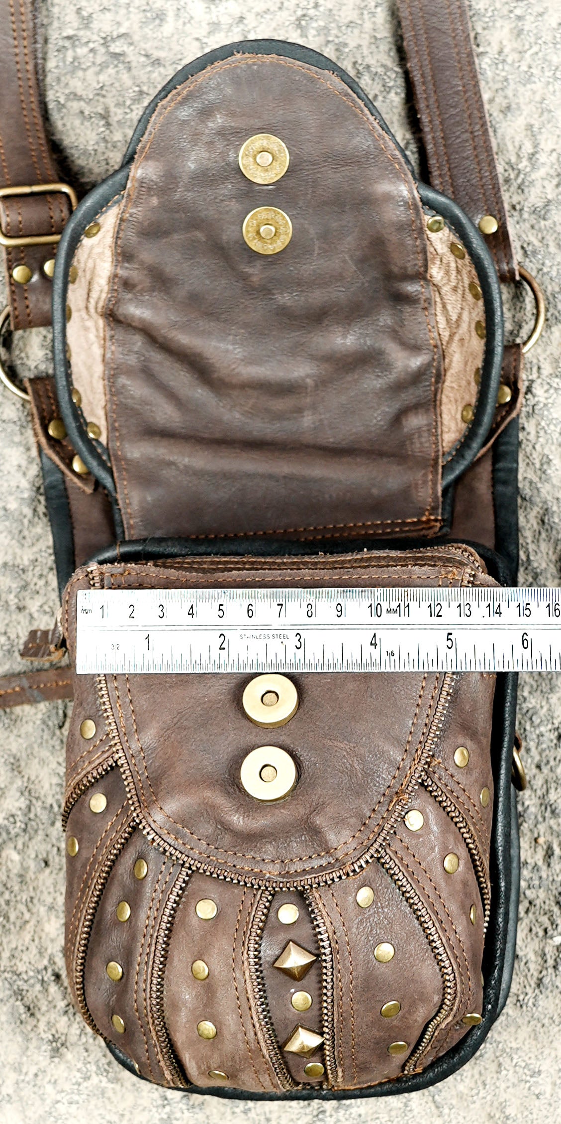 Brown leather steampunk accessory featuring twin bags and a decorative gemstone chest panel