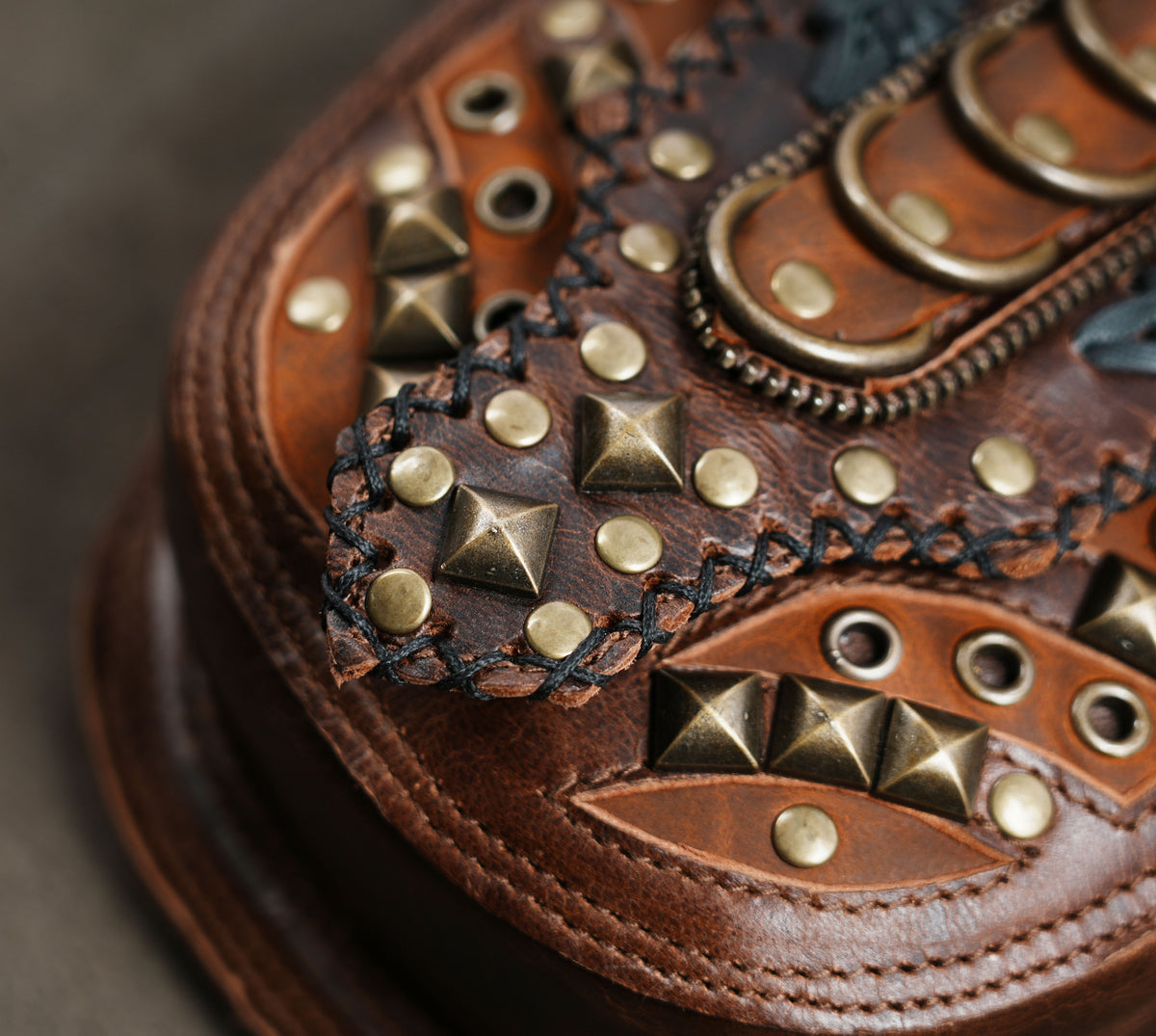 Brown leather double holster bag with studded flaps and adjustable straps