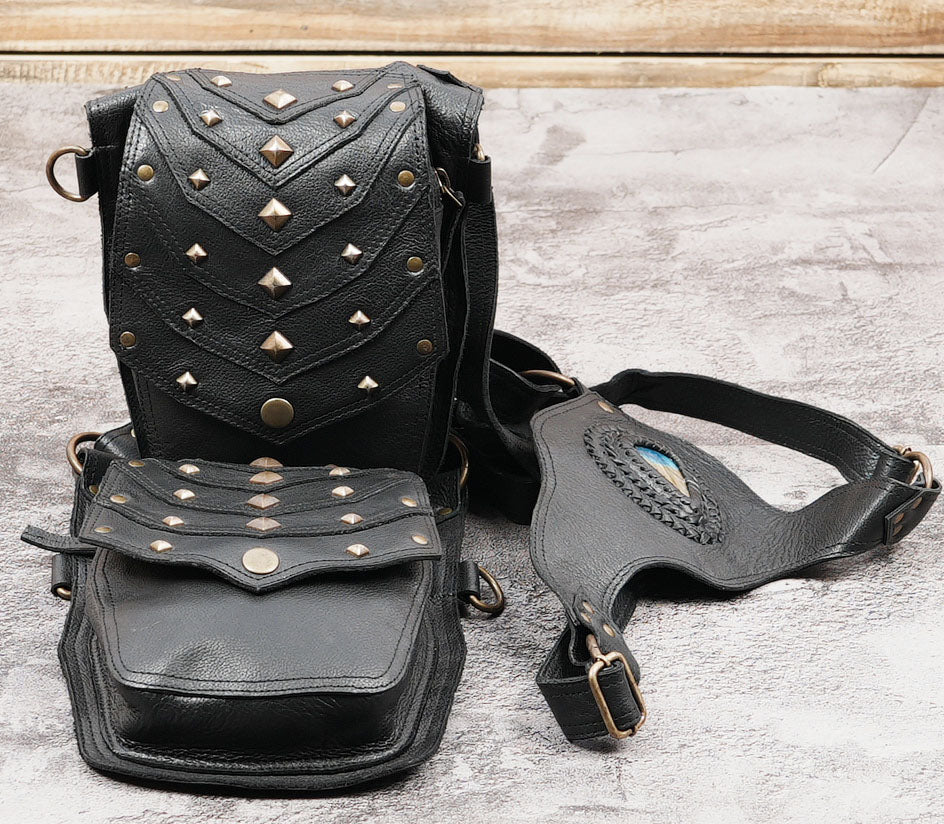 Black leather harness shoulder bag with decorative studs and gemstone accent