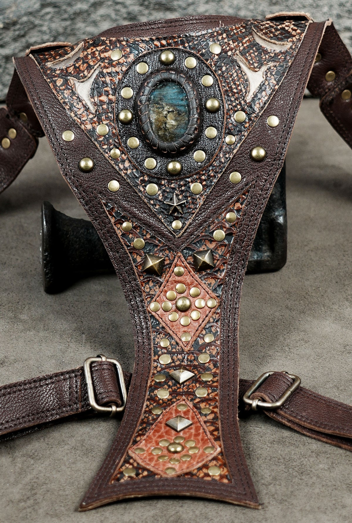 Leather dual pouch harness bag with adjustable buckles and detailed studded decorations.