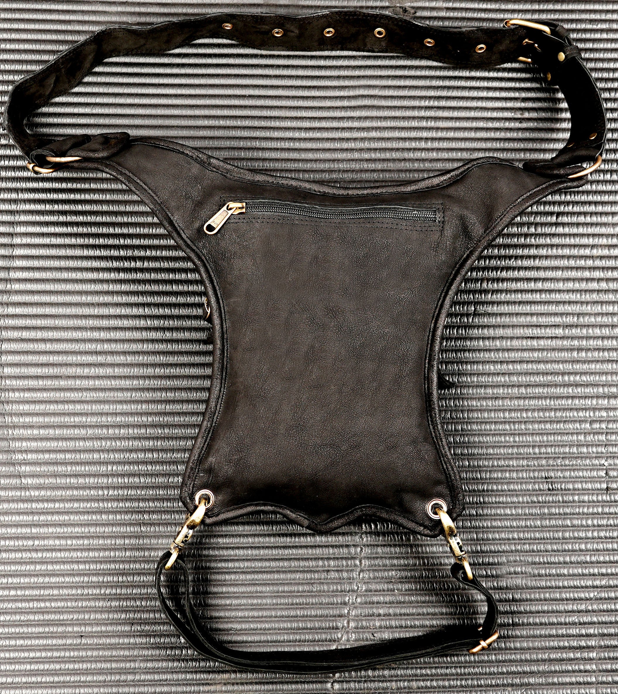 Punk-style black leather thigh bag with brass hardware