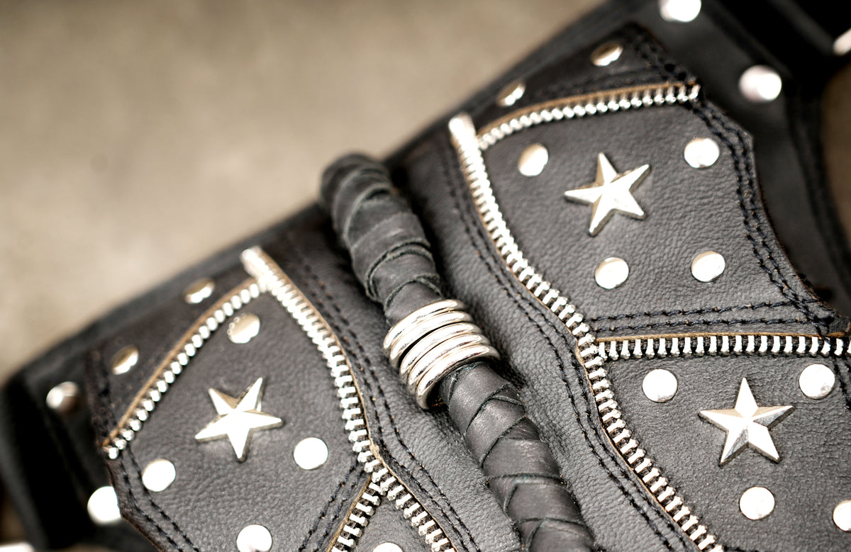 Punk leather pouch with nickel star studs, close up view