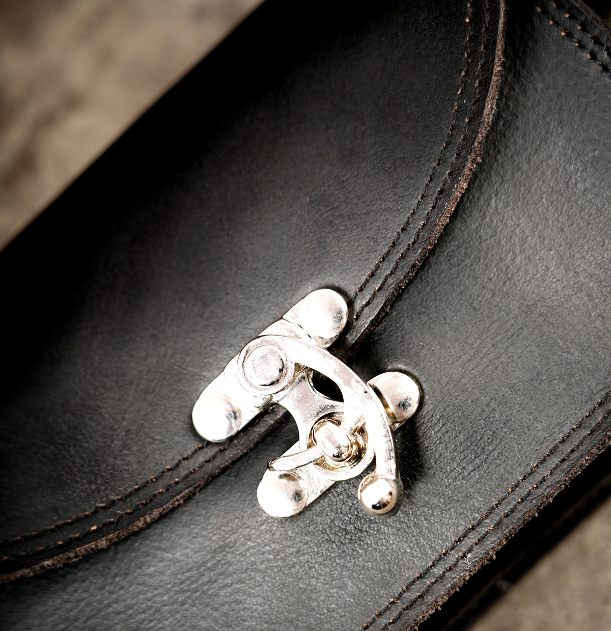 Sleek black leather pouch with silver clasp detail