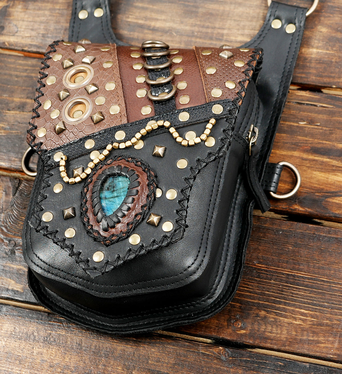 Brown leather flap design on black double hip pouch harness with antique brass hardware
 