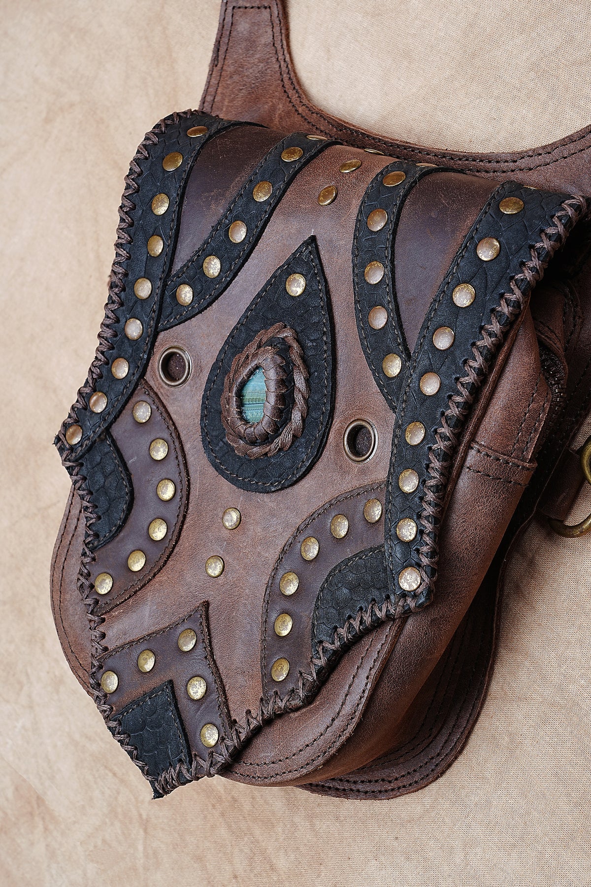 Brown leather utility harness with two storage pockets and decorative gemstone centers