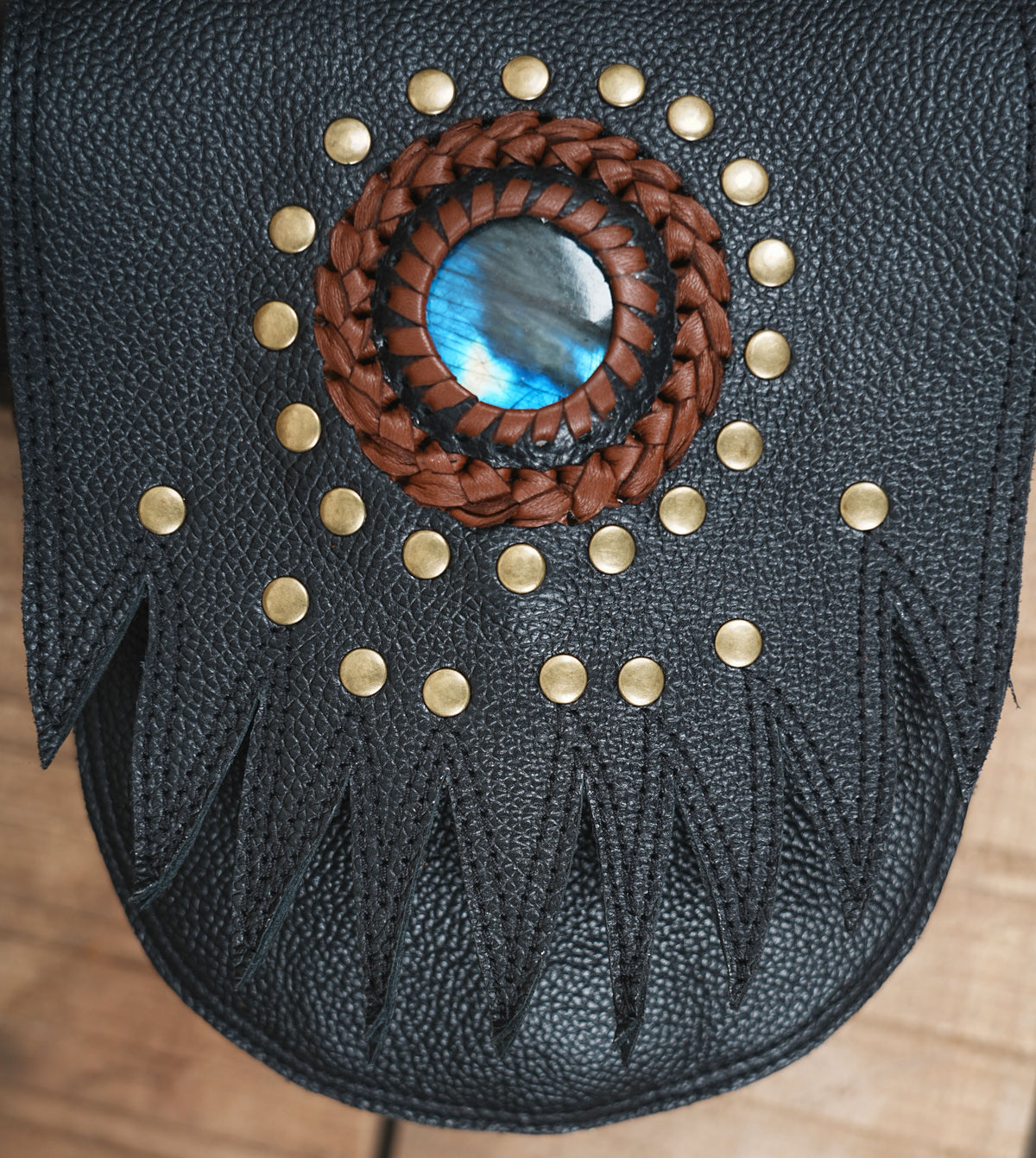 Black leather festival chest rig with studded pockets gemstone centerpiece and brass hardware