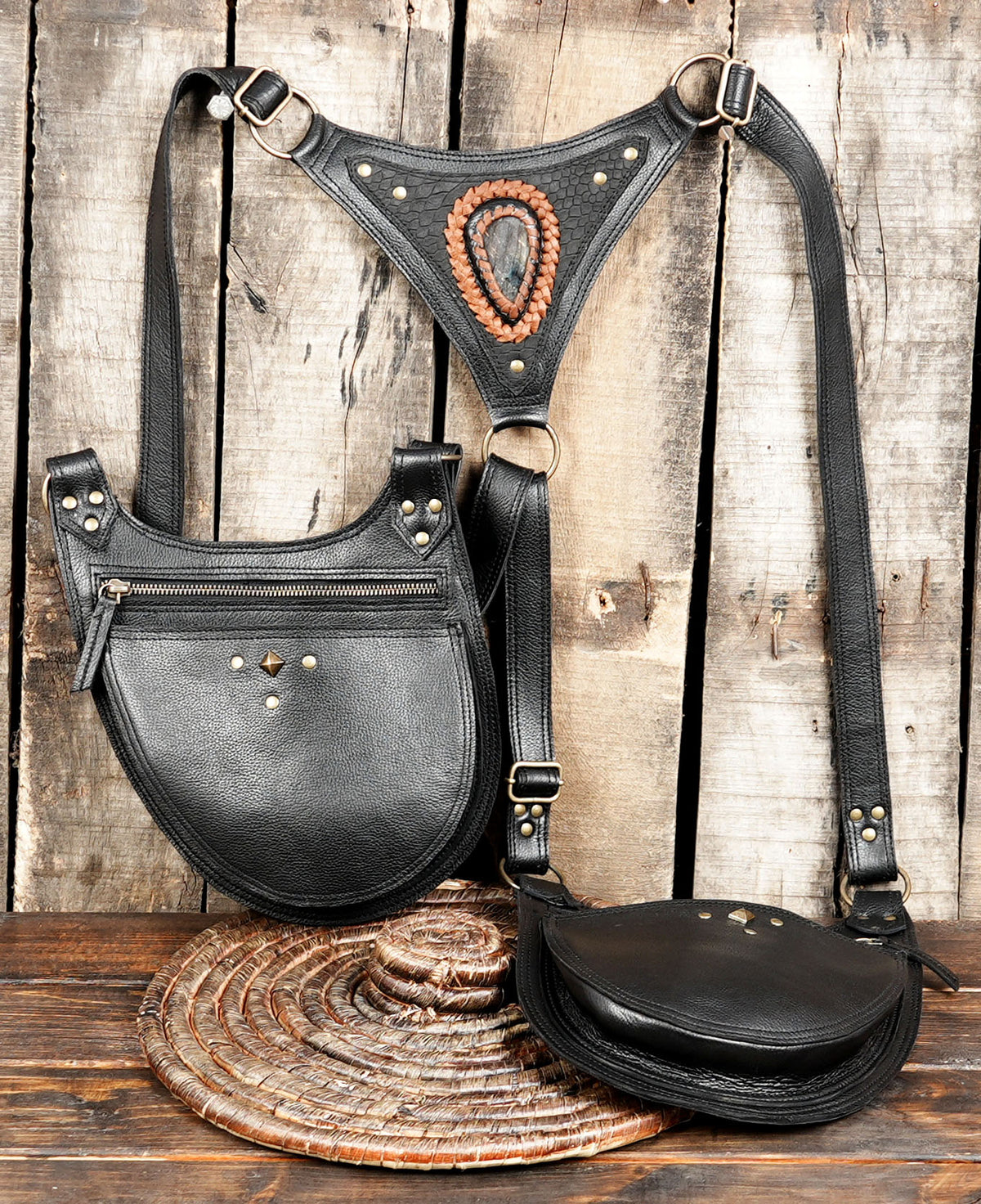 Black leather shoulder harness with two storage pouches and antique brass buckles for festival outfits.
