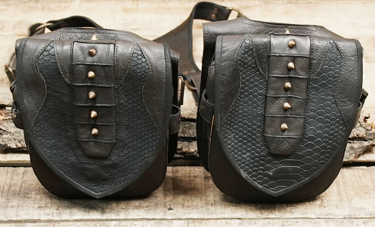 Black leather utility pouch set with adjustable harness straps and antique brass hardware