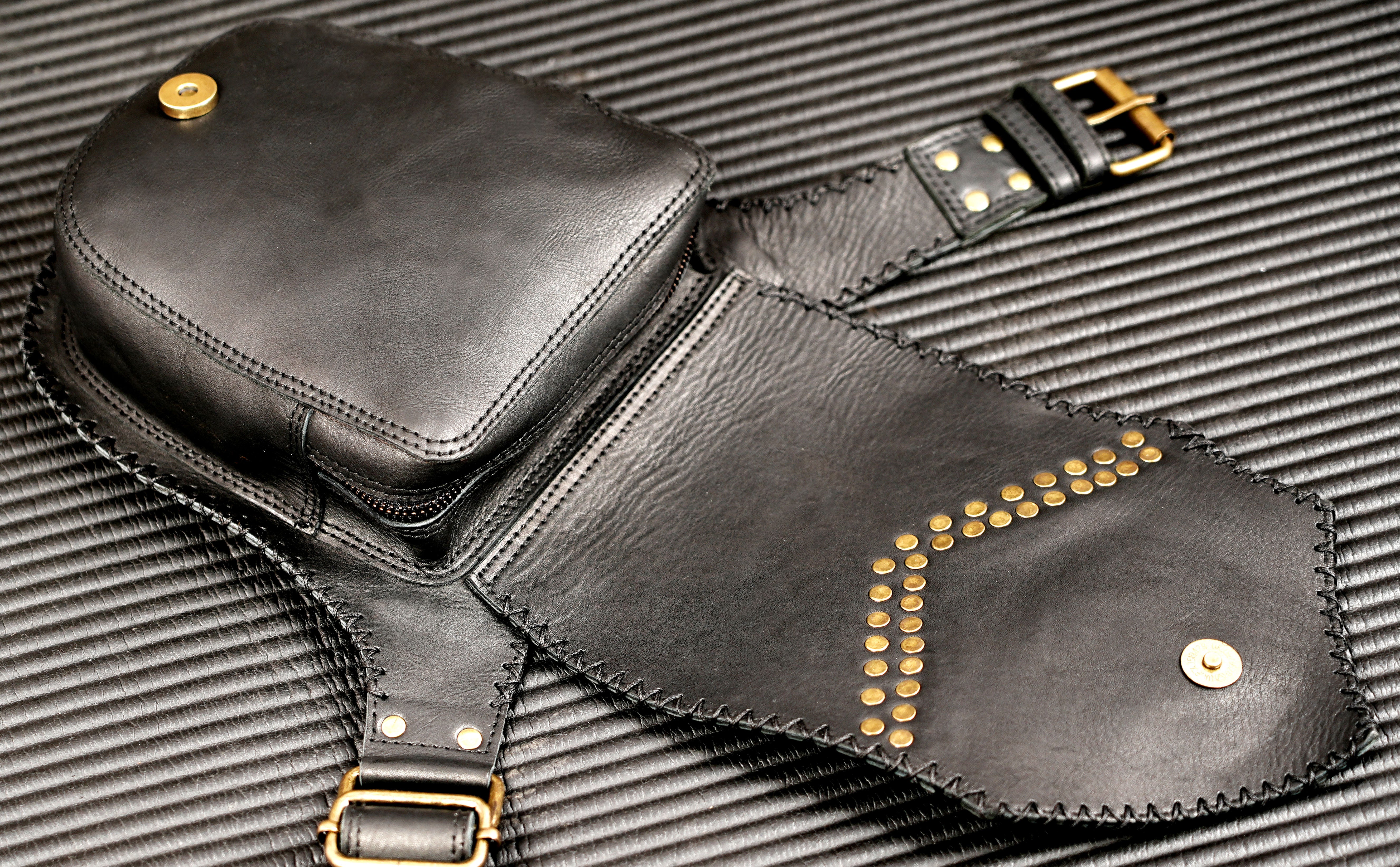 Vintage-inspired black belt pouch with brass stud detailing