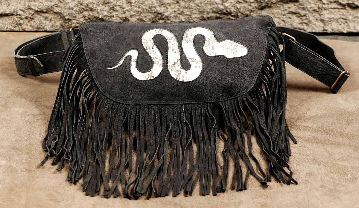 Women's black fringe hip pouch with white snake artwork and adjustable waist strap.