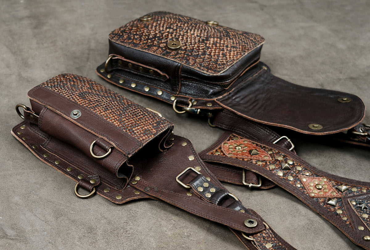 Brown leather harness pouch set with studded borders and an ornate central gemstone design.
