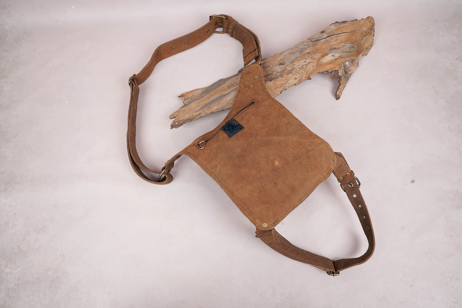 Compact leather waist holster with secure buckle and strap system