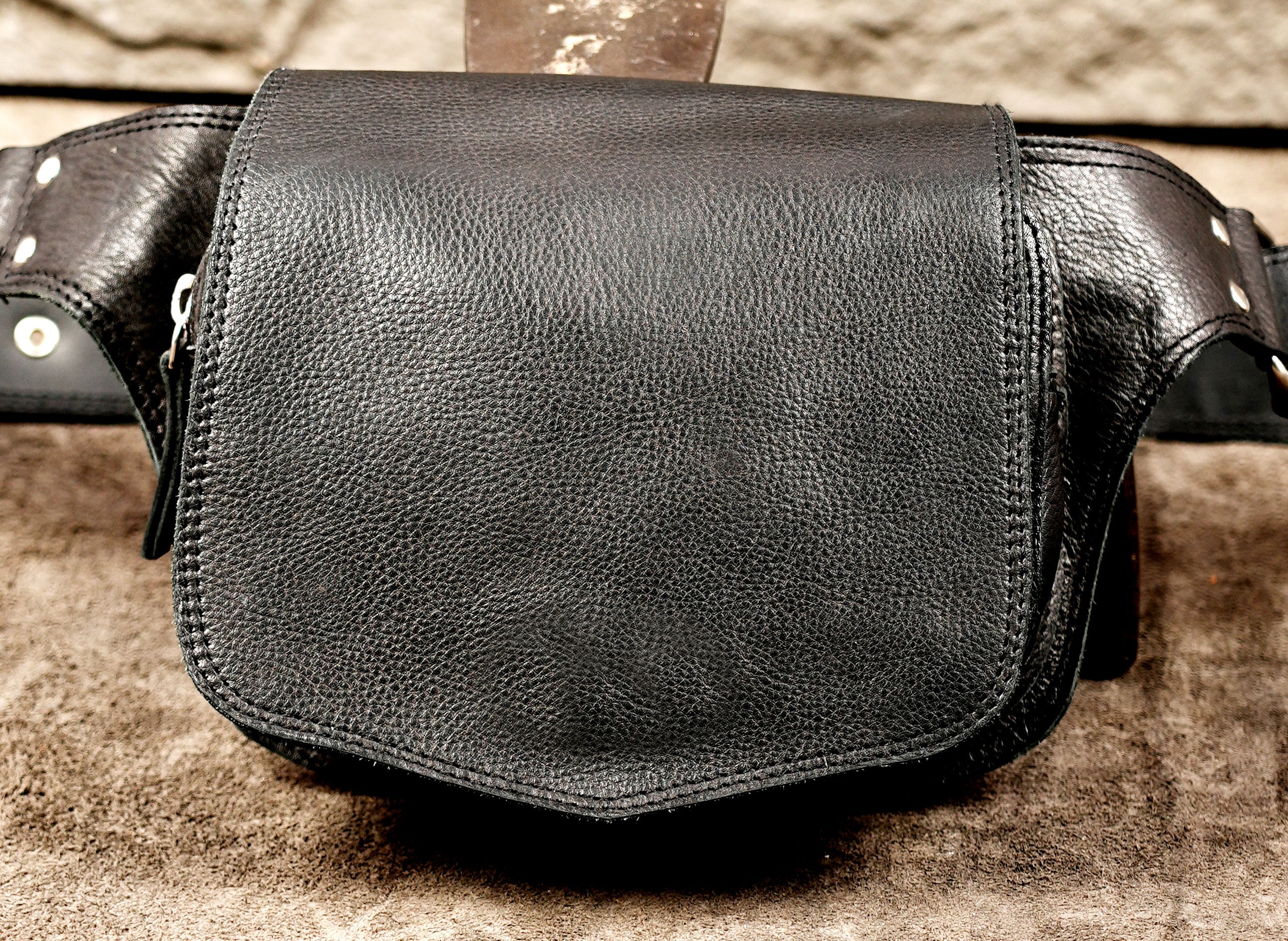 Minimalist leather waist bag with nickel silver D-rings, flat lay