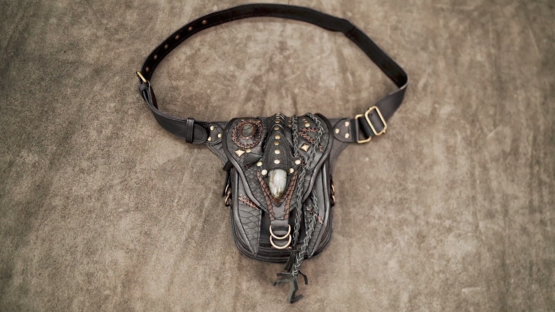 Boho style leather hip bag featuring a central teardrop gemstone and tribal stitching.