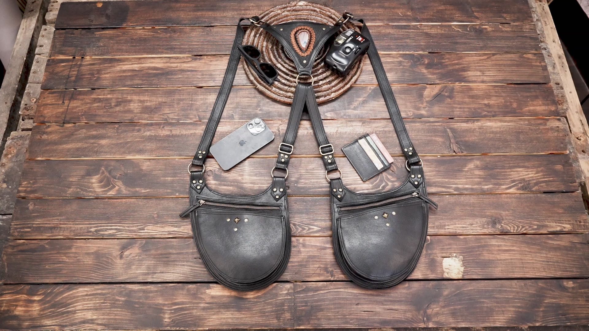 Black leather festival harness with two zippered utility pouches and brass tone fittings.