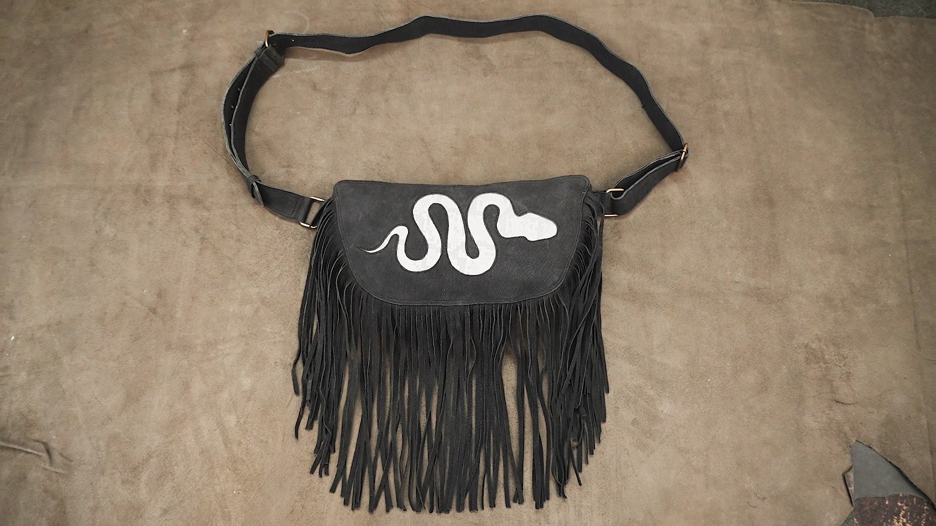 Black fringe utility hip pouch with white snake design for Burning Man accessories.