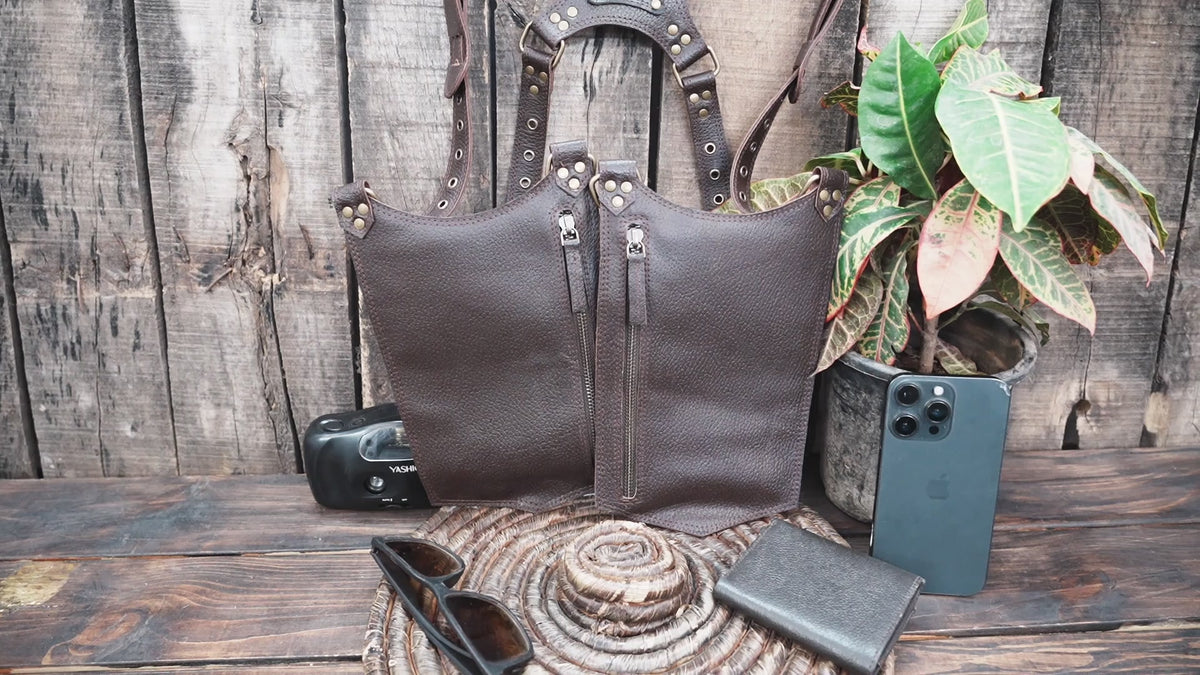 Brown leather double holster harness with adjustable leg straps and secure metal fasteners.