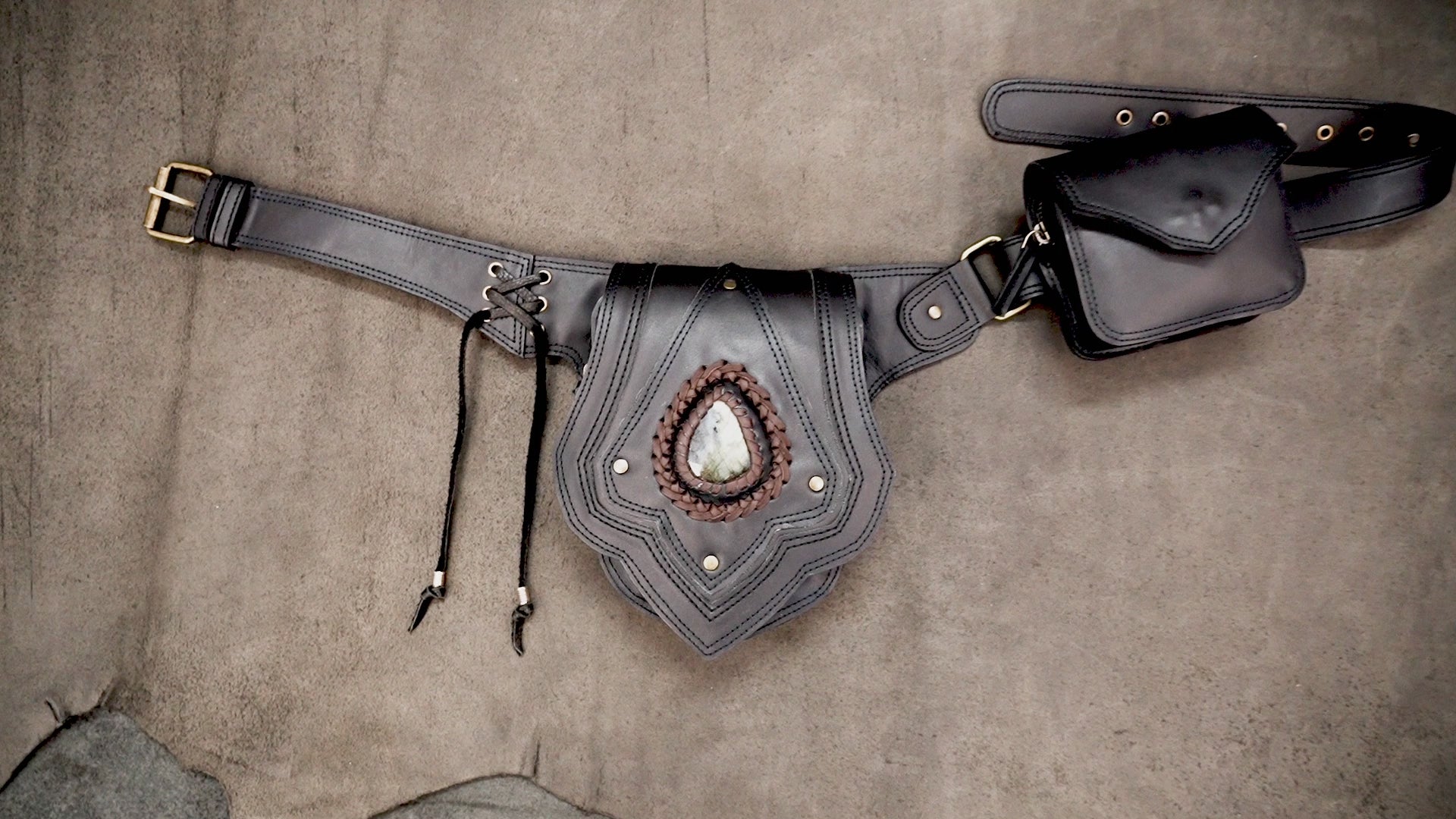 Black leather utility waist bag with decorative stone center pocket