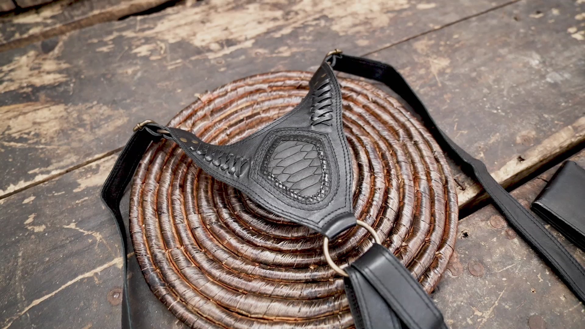 Handmade black leather shoulder holster with decorative flap details and antique brass hardware