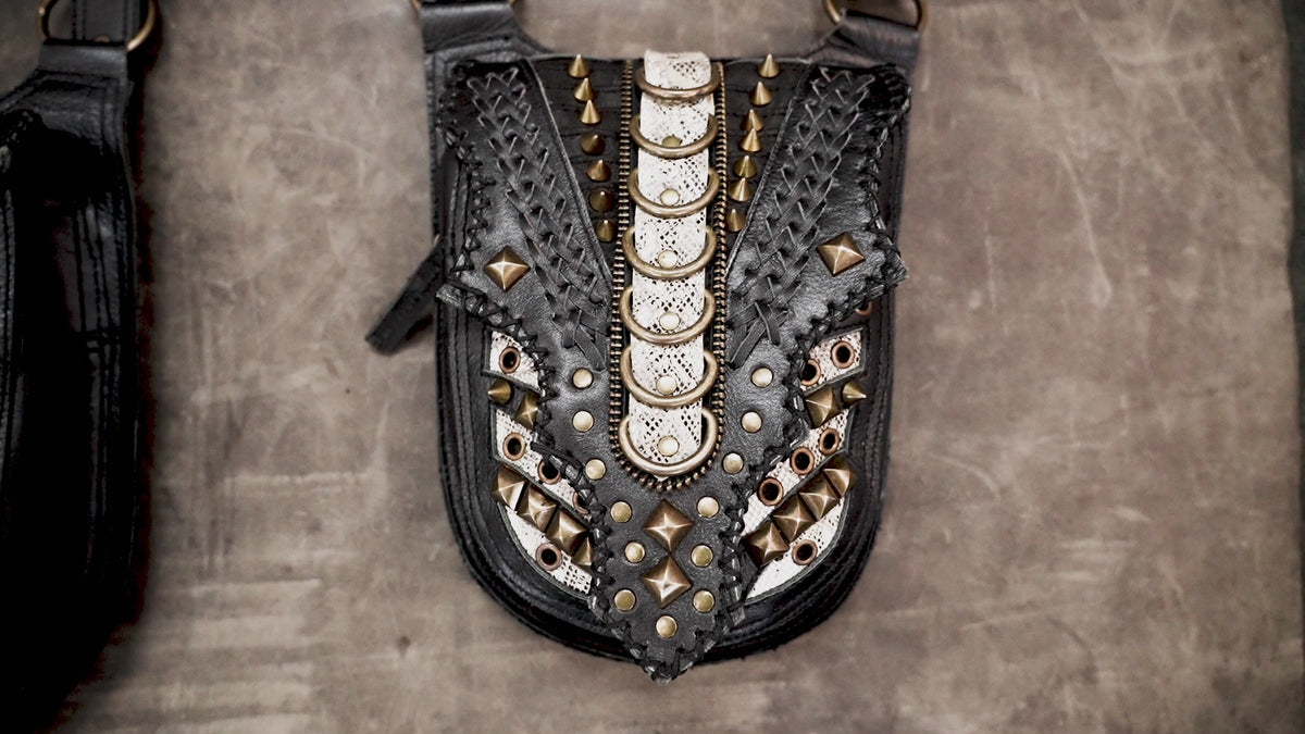 Handcrafted leather dual pouch harness featuring metallic hardware and adjustable shoulder straps