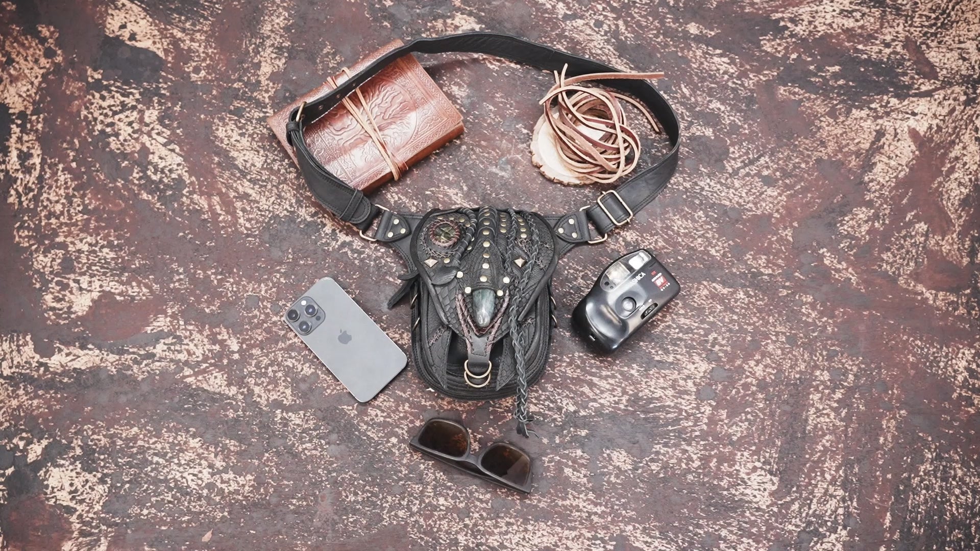 "Artisan leather hip bag with braided details and brass studs"