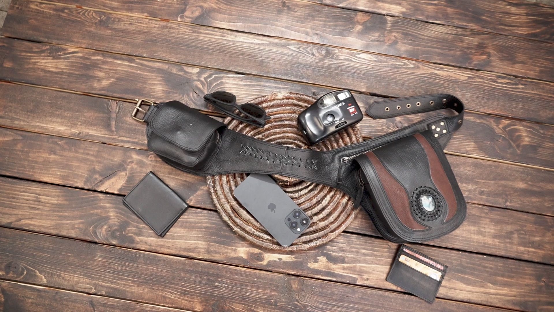 Artisan leather waist pouch belt with dual storage compartments flat lay on wood background