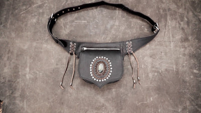Boho style black leather fanny pack featuring silver studs and a raw stone crystal.