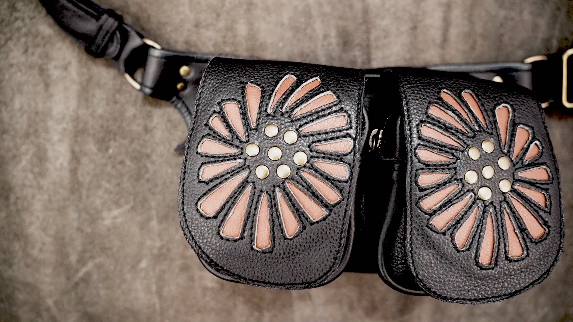 Floral leather waist bag with dual pockets and decorative antique brass rivets.